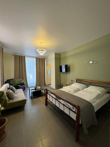 a bedroom with a large bed and a couch at Basalt Appartements Gyumri in Gyumri