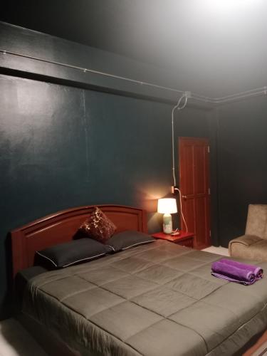 a bedroom with a large bed and a chair at HiSSS Style ชะอำ in Cha Am