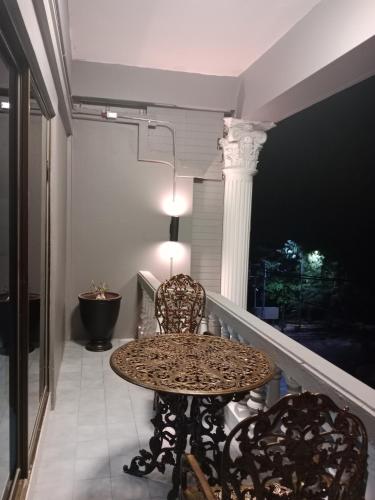 a table and chairs on a balcony with a column at HiSSS Style ชะอำ in Cha Am