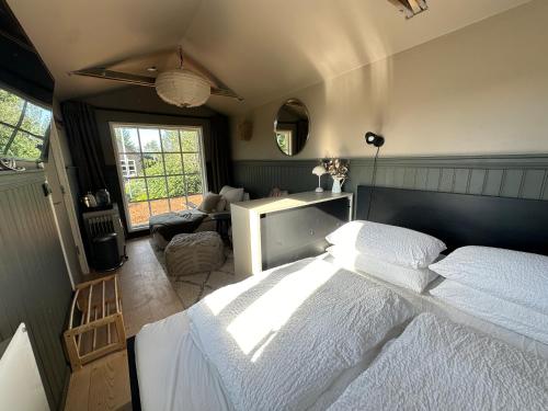 a bedroom with a large white bed and a window at Cosy and modern Chalet in Grímsnes, south of Iceland - Birta Rentals in Kerhraun