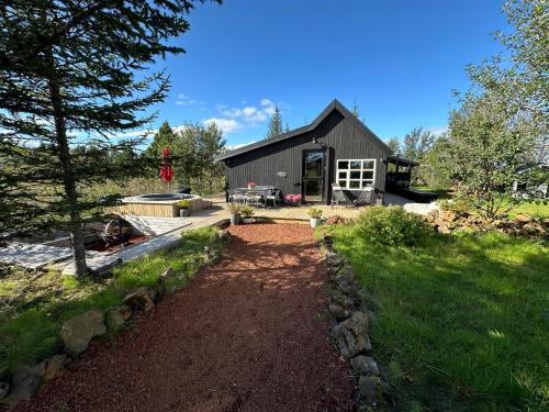 a house with a garden and a yard sidx sidx sidx at Cosy and modern Chalet in Grímsnes, south of Iceland - Birta Rentals in Kerhraun