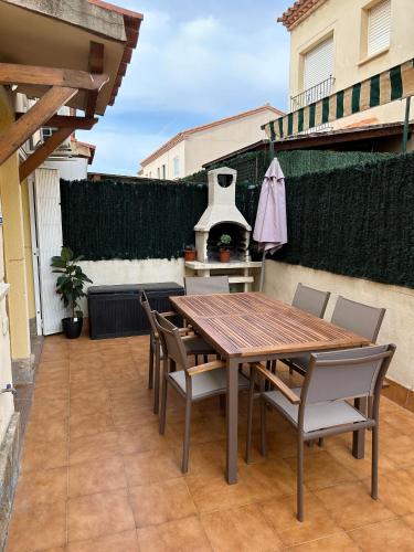 a wooden table and chairs on a patio at Casa adosada en Vilafortuny, Cambrils in Cambrils