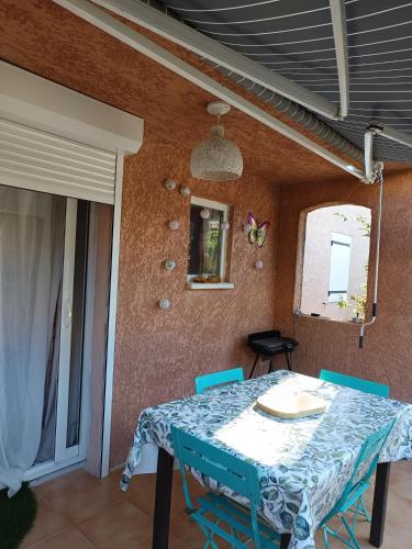 une salle à manger avec une table et des chaises bleues dans l'établissement La maison papillons, à Quissac