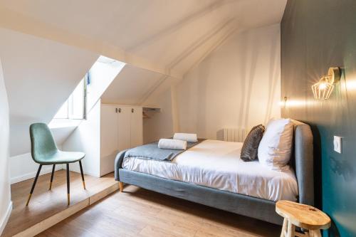 une chambre avec un lit et une chaise dans l'établissement SENTIER, MARAIS, spacieux duplex 2 salles de bain, à Paris