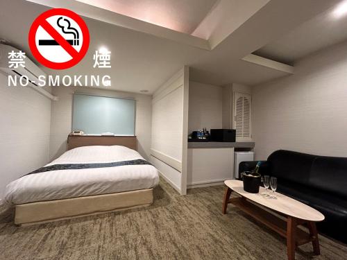 a hotel room with a bed and a no smoking sign at ホテルアイエス in Yokohama