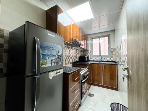 a large kitchen with a stainless steel refrigerator at Baraha Star Residence in Dubai