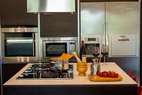 a kitchen with a stove and a counter with wine glasses at Villa Dolce Vita - Vista Colline, Jacuzzi, 3Suites & 5min dal mare in Lapedona