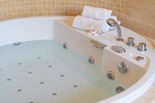 a white bath tub with a faucet and towels at Villa Dolce Vita - Vista Colline, Jacuzzi, 3Suites & 5min dal mare in Lapedona
