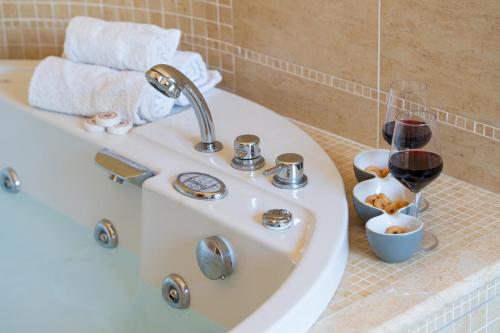 a bathroom sink with two glasses of wine at Villa Dolce Vita - Vista Colline, Jacuzzi, 3Suites & 5min dal mare in Lapedona