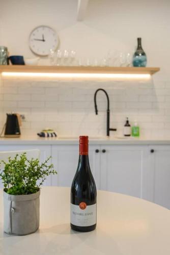 a bottle of wine sitting on a counter in a kitchen at Blairgowrie Beach Townhouse Opposite the beach! in Blairgowrie