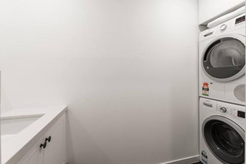 a white laundry room with a washer and dryer at Blairgowrie Beach Townhouse Opposite the beach! in Blairgowrie