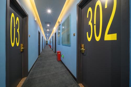 a hallway with blue walls and yellow doors with a hallway at QiQiaoWu Fashion Hotel - Beijing Songjiazhuang Subway Station in Beijing