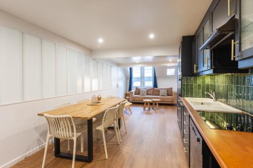 une cuisine et une salle à manger avec une table et des chaises en bois dans l'établissement SENTIER, MARAIS, spacieux duplex 2 salles de bain, à Paris