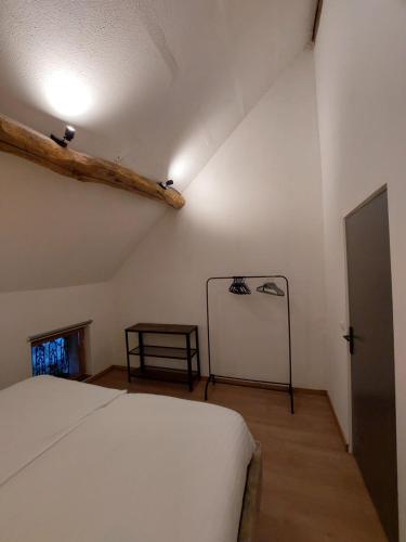 a bedroom with a white bed and a wooden floor at Gite Charassat in Saint-Marcel-en-Marcillat