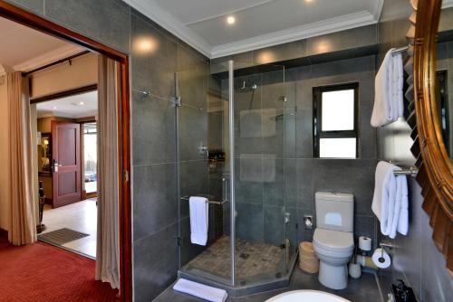 a bathroom with a toilet and a glass shower at The Residence in Johannesburg