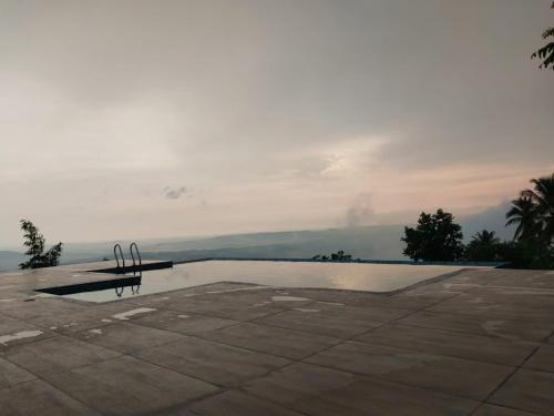 a swimming pool with a bench in front of it at Whiteflower Mountain Resort in Perintalmanna