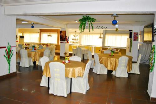 a banquet hall with tables and white chairs at Riviera Hotel Benin in Cotonou