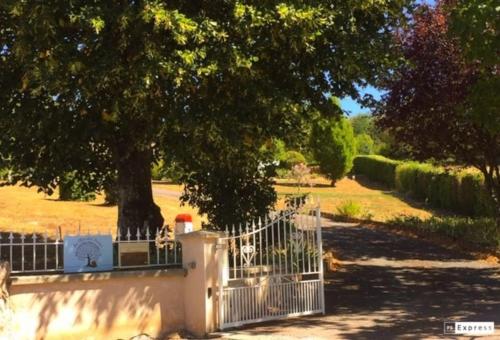 une clôture blanche devant un arbre dans l'établissement Au Clos des Ormes, à Dompierre-les-Ormes