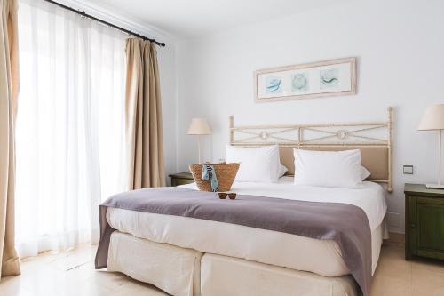 a bedroom with a large bed and a large window at Ona Lomas Village - La Manga Club in La Manga del Mar Menor