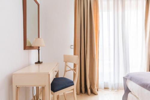 a bedroom with a desk and a bed and a mirror at Ona Lomas Village - La Manga Club in La Manga del Mar Menor