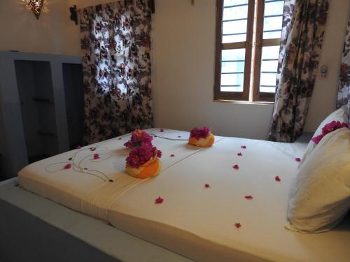 a bed with flower petals on it with flowers on it at Stonefish Inn Jambiani in Jambiani