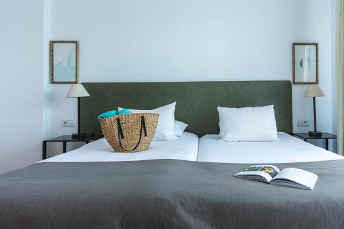 a bedroom with two beds and a book on the bed at Ona Lomas Village - La Manga Club in La Manga del Mar Menor