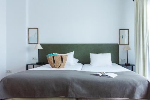 a bedroom with a large bed with two books on it at Ona Lomas Village - La Manga Club in La Manga del Mar Menor