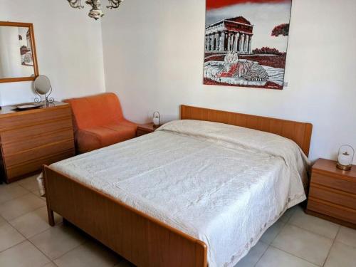 a bedroom with a bed and a chair in it at Da Nonna Gina - in centro con parcheggio gratuito in Paestum
