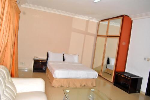 a hotel room with two beds and a mirror at Riviera Hotel Benin in Cotonou