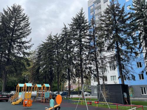 un patio de juegos con equipos de juego en un parque en Апартаменты, ЖК Еламан, мкр Калкаман, Больница, en Almaty