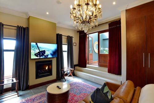a living room with a fireplace and a television at The Residence in Johannesburg