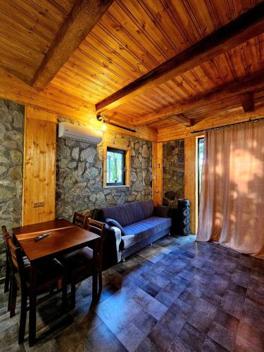 a living room with a couch and a table at Iveria Parky and cottages in Shekvetili