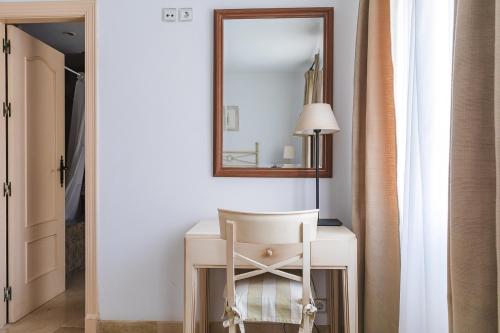 a white desk with a chair and a mirror at Ona Lomas Village - La Manga Club in La Manga del Mar Menor