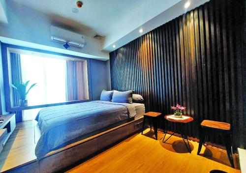 バタム・センターにあるNewly Renovated 55th Floor Seaview Unit Pollux Batamのベッドルーム1室(ベッド1台、窓、テーブル付)