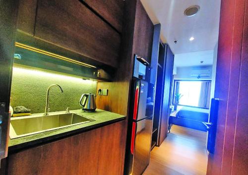 バタム・センターにあるNewly Renovated 55th Floor Seaview Unit Pollux Batamのシンクと冷蔵庫付きのキッチン