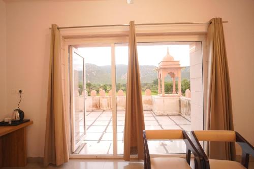 a room with a sliding glass door with a view at Dhawala Resort By Aamod in Alwar