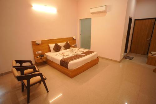 a bedroom with a bed and a chair in it at Dhawala Resort By Aamod in Alwar