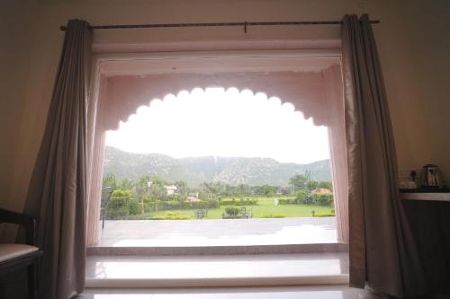 a window with a view of a park at Dhawala Resort By Aamod in Alwar