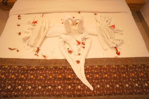 a bed with two towels and flowers on it at Dhawala Resort By Aamod in Alwar