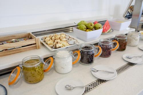 a kitchen counter with jars of food and other ingredients at Phos Hotel Adults Only in Plataniás