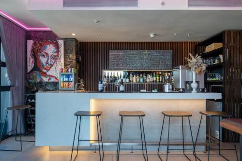 a bar in a restaurant with stools at Modern 14th floor Apt with Balcony & Mountain Views at 16onBree in Cape Town
