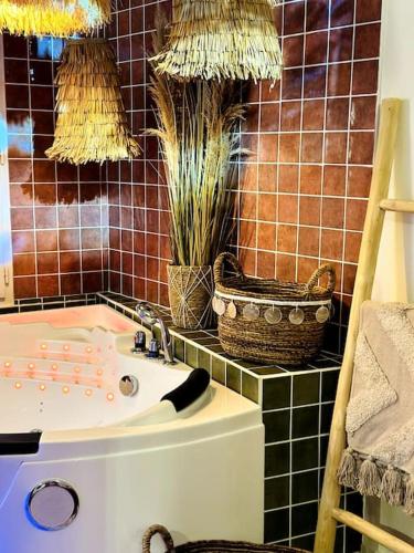 a bathroom with a tub and a sink with plants at Suite Marrakech - Rennes centre in Rennes