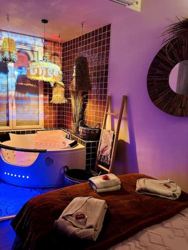a bedroom with a tub and a bed with towels on it at Suite Marrakech - Rennes centre in Rennes
