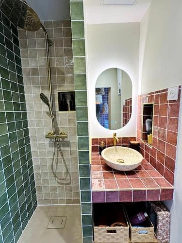a bathroom with a sink and a shower with a mirror at Suite Marrakech - Rennes centre in Rennes