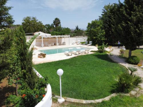 a backyard with a swimming pool and a lawn at Villa Dei Lidi - HomeSalento com in Torre San Giovanni Ugento