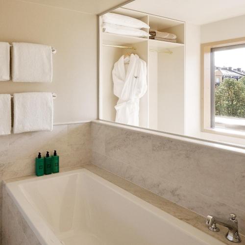 a white bath tub in a bathroom with a mirror at Villa Dahlia in Stockholm