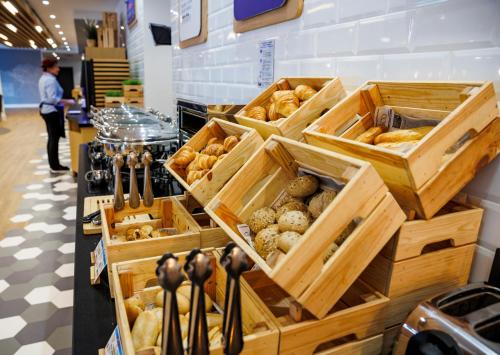a bakery with wooden boxes filled with different types of bread at Holiday Inn Express Bilbao Airport by IHG in Derio