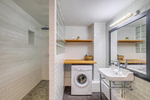 une salle de bain avec une machine à laver et un lavabo dans l'établissement MONTMARTRE Sacré-Coeur, appartement jardin 6 à 8P, à Paris
