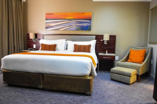 a hotel room with a large bed and a chair at Cresta Mahalapye Hotel in Mahalapye