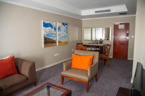 a living room with a couch and a chair and a table at Cresta Mahalapye Hotel in Mahalapye